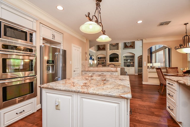 37703 Edgewater Dr, Pinehurst, TX 77362 - kitchen featuring stainless steel appliances, arched walkways, crown molding, open floor plan, and a center island