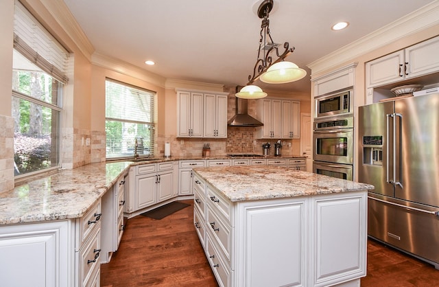 37703 Edgewater Dr, Pinehurst, TX 77362 - kitchen with appliances with stainless steel finishes, ornamental molding, wall chimney exhaust hood, dark wood-style flooring, and a center island