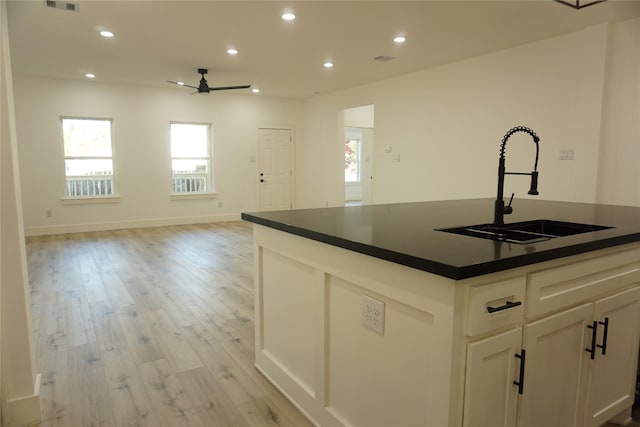 kitchen with a sink, dark countertops, and a healthy amount of sunlight
