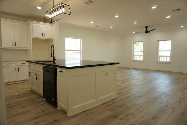 kitchen featuring dark countertops, dishwasher, a sink, and ceiling fan