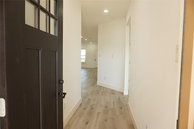 hallway with light wood-type flooring, baseboards, and recessed lighting