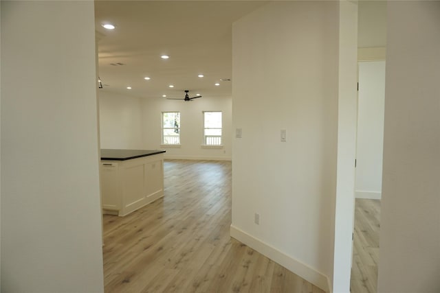 corridor with recessed lighting, light wood finished floors, and baseboards