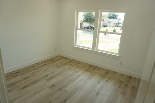 unfurnished room featuring light wood-type flooring and baseboards