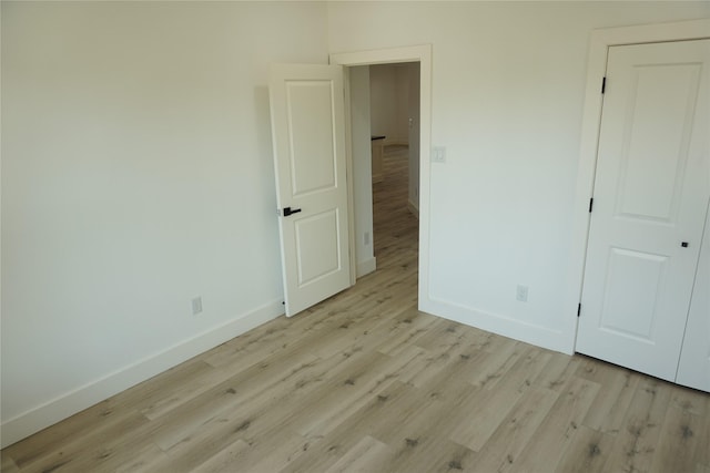 unfurnished bedroom with light wood finished floors and baseboards