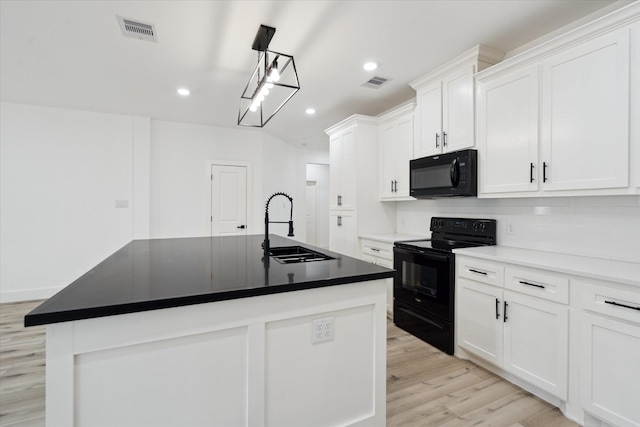 6319 Ivyknoll Dr, Houston, TX 77035 - kitchen with black appliances, a sink, recessed lighting, white cabinets, and an island with sink