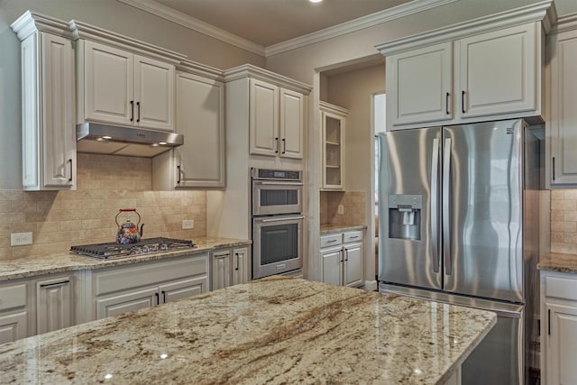 271 Spotted Saddle Ct, The Woodlands, TX 77382 - kitchen with stainless steel appliances, under cabinet range hood, light stone countertops, and decorative backsplash
