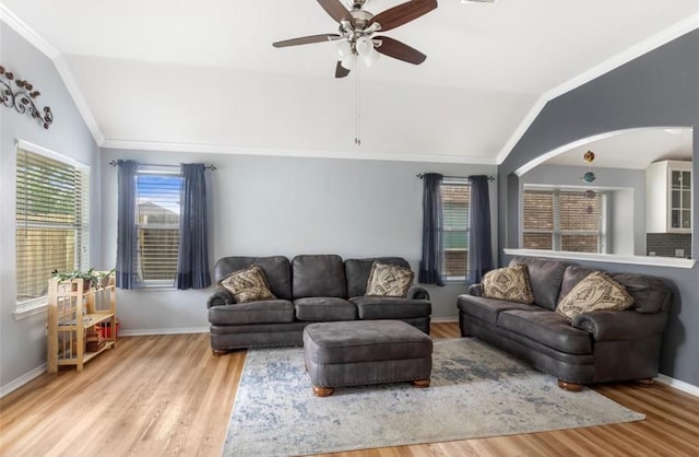 living area featuring wood finished floors, ceiling fan, ornamental molding, and lofted ceiling