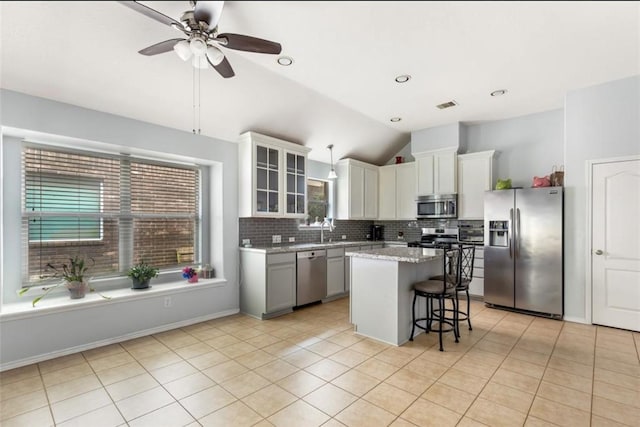 kitchen with tasteful backsplash, visible vents, a kitchen breakfast bar, stainless steel appliances, and lofted ceiling