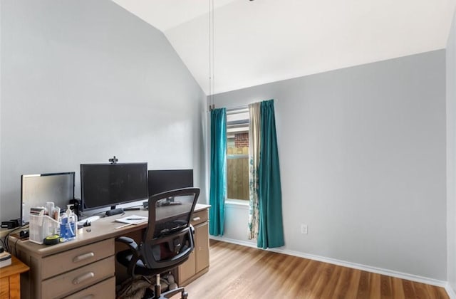 home office featuring light wood-style floors, baseboards, and vaulted ceiling