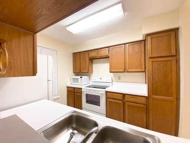 10555 Turtlewood Ct Unit 2102, Houston, TX 77072 - kitchen with a sink, light countertops, brown cabinetry, and white appliances