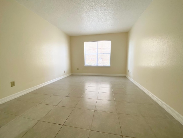 10555 Turtlewood Ct Unit 2102, Houston, TX 77072 - spare room featuring baseboards, light tile patterned flooring, and a textured ceiling