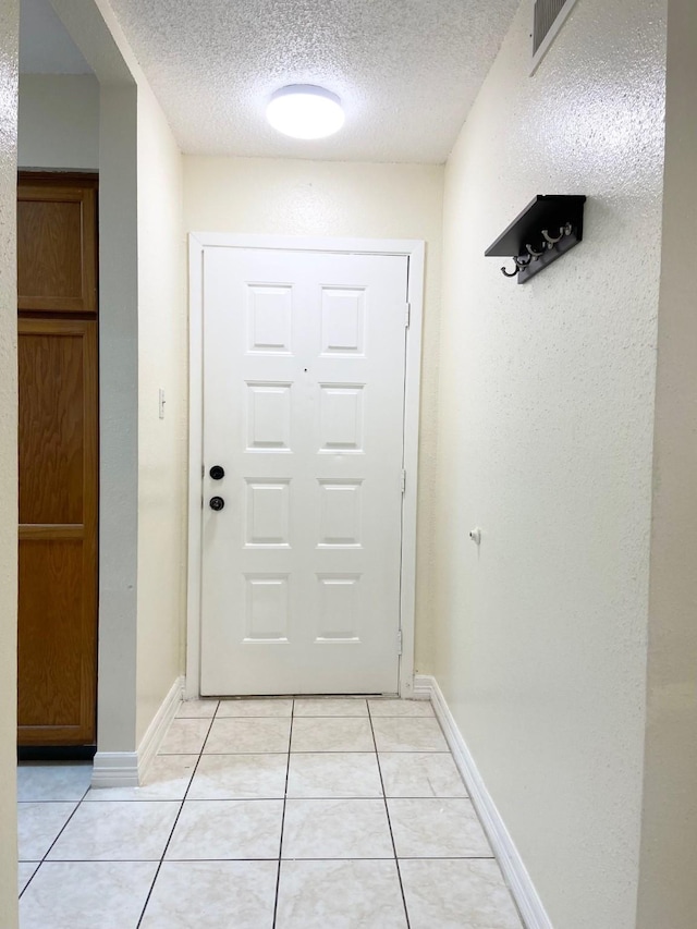 10555 Turtlewood Ct Unit 2102, Houston, TX 77072 - entryway featuring visible vents, baseboards, light tile patterned flooring, and a textured ceiling