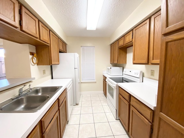 10555 Turtlewood Ct Unit 2102, Houston, TX 77072 - kitchen featuring white appliances, a textured ceiling, light countertops, a sink, and brown cabinets