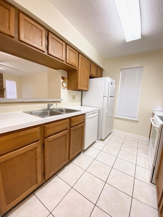 10555 Turtlewood Ct Unit 2102, Houston, TX 77072 - kitchen with a sink, light countertops, white appliances, brown cabinetry, and light tile patterned flooring