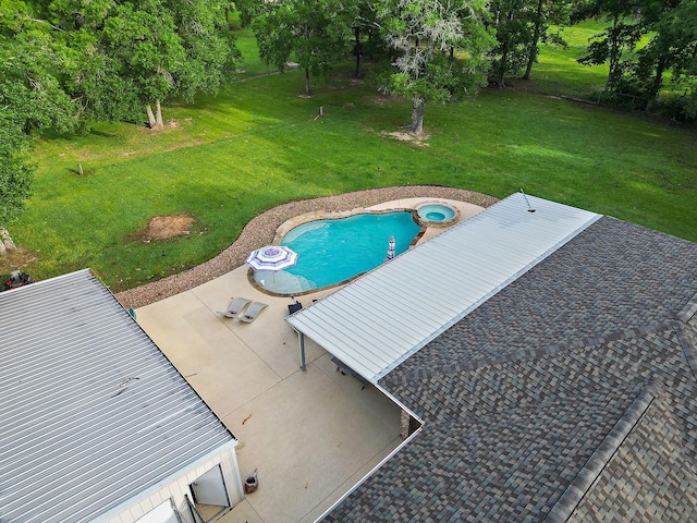 view of swimming pool featuring a patio area, a pool with connected hot tub, and a yard
