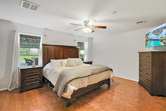 bedroom featuring visible vents, baseboards, light wood finished floors, and a ceiling fan