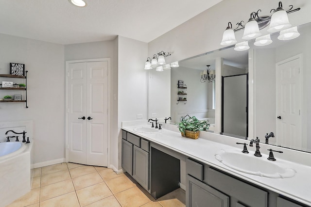 bathroom with a chandelier, a garden tub, a sink, and tile patterned flooring