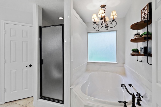 bathroom featuring a shower stall, tile patterned floors, a garden tub, and an inviting chandelier