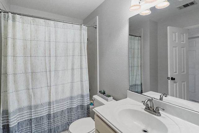 full bathroom featuring visible vents, toilet, a shower with shower curtain, and vanity