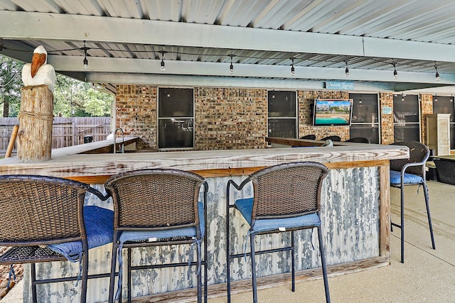 view of patio with a bar and fence