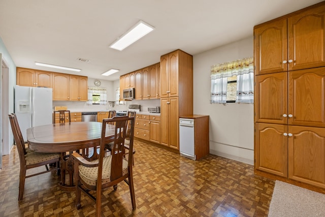 kitchen with a wealth of natural light, stainless steel appliances, visible vents, and light countertops