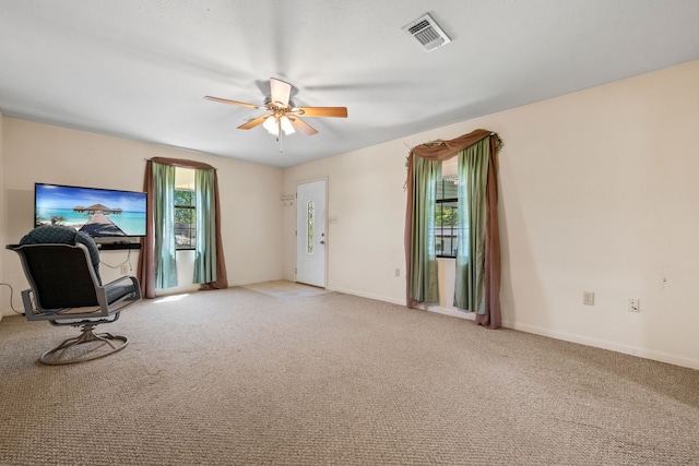 interior space featuring ceiling fan, baseboards, carpet flooring, and visible vents
