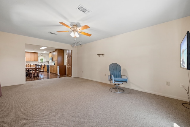 unfurnished room with dark colored carpet, visible vents, a ceiling fan, and baseboards