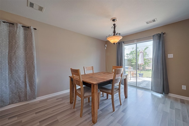 dining space with visible vents, light wood-style flooring, and baseboards
