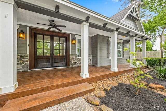 5511 Oak Cove Dr, Kingwood, TX 77345 - doorway to property featuring a ceiling fan, fence, covered porch, french doors, and stone siding