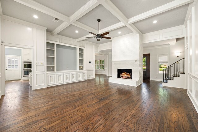 5511 Oak Cove Dr, Kingwood, TX 77345 - unfurnished living room featuring beam ceiling, dark wood finished floors, visible vents, a ceiling fan, and a fireplace