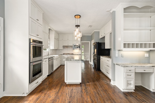 5511 Oak Cove Dr, Kingwood, TX 77345 - kitchen featuring white cabinets, a center island, a sink, and appliances with stainless steel finishes