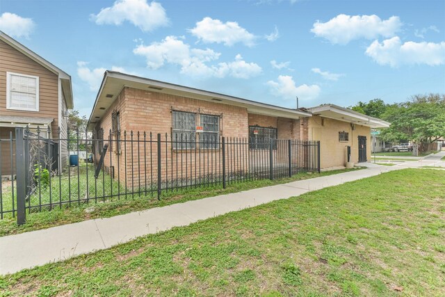 7846 Dayton St, Houston, TX 77012 - view of front of property featuring a front yard, brick siding, and fence private yard