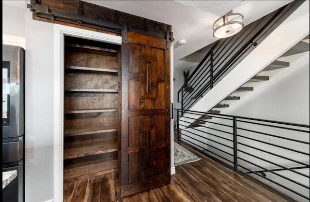 12500 Melville Dr Unit 211, Montgomery, TX 77356 - stairway featuring a barn door and wood finished floors