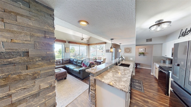 12500 Melville Dr Unit 211, Montgomery, TX 77356 - kitchen with black electric range, stainless steel fridge with ice dispenser, dark wood-style flooring, white cabinetry, and open floor plan