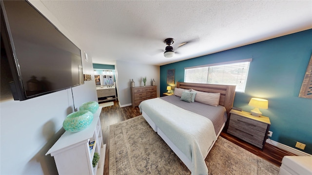 12500 Melville Dr Unit 211, Montgomery, TX 77356 - bedroom with wood finished floors, a textured ceiling, a ceiling fan, and ensuite bathroom