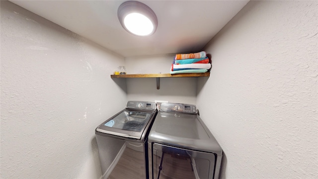 12500 Melville Dr Unit 211, Montgomery, TX 77356 - laundry area featuring washing machine and dryer, wood finished floors, and a textured wall