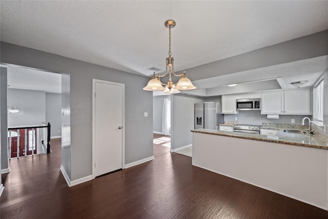 kitchen with a sink, dark wood-style flooring, white cabinetry, stainless steel appliances, and light stone counters