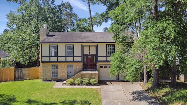 english style home with an attached garage, fence, stucco siding, a front lawn, and driveway