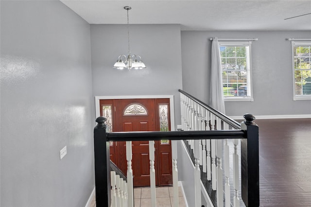 foyer featuring baseboards and a chandelier