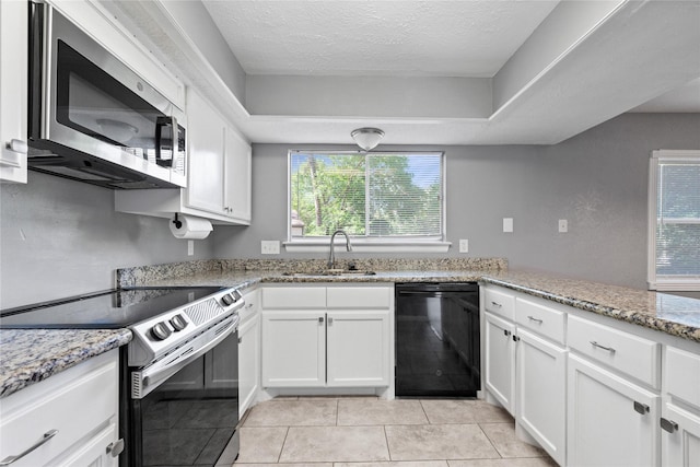kitchen with a textured ceiling, appliances with stainless steel finishes, a sink, and white cabinets