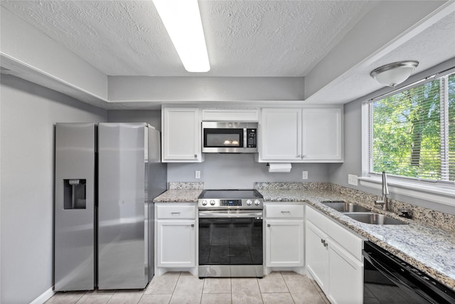 kitchen with appliances with stainless steel finishes, a sink, and white cabinets