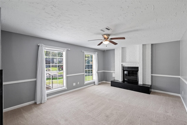 unfurnished living room featuring visible vents, ceiling fan, carpet floors, and a textured ceiling