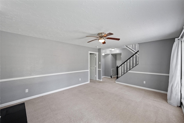 unfurnished living room featuring visible vents, baseboards, and a ceiling fan