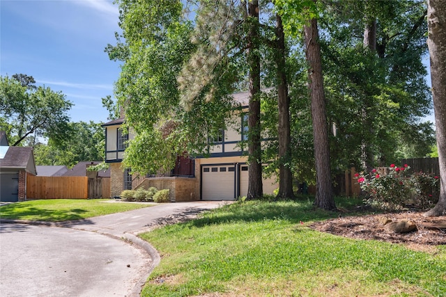 view of front of house featuring a garage, fence, concrete driveway, brick siding, and a front lawn