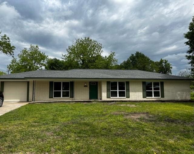 ranch-style house with a garage, driveway, a front lawn, and brick siding