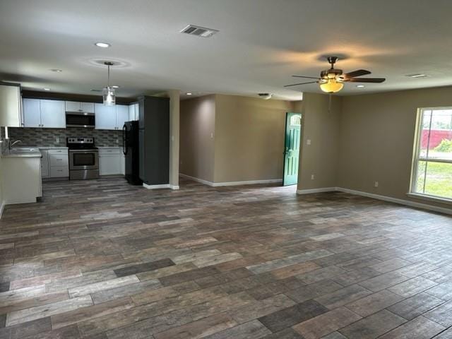unfurnished living room featuring visible vents, baseboards, dark wood-type flooring, recessed lighting, and a ceiling fan