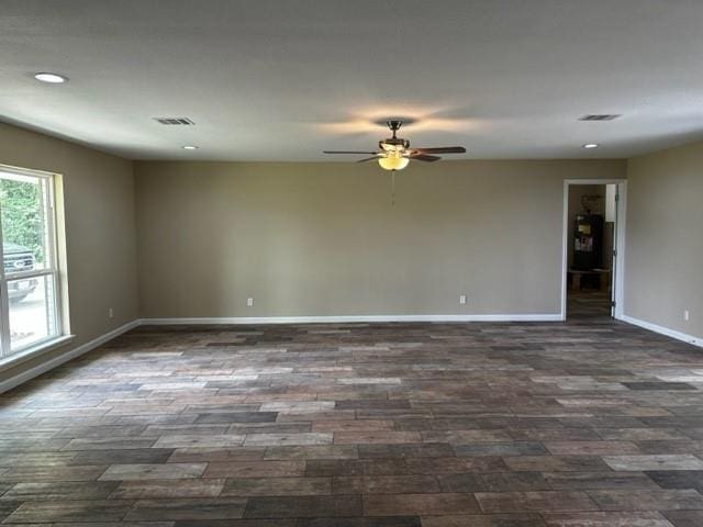 spare room with ceiling fan, visible vents, baseboards, recessed lighting, and dark wood-type flooring