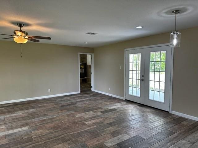 unfurnished room with visible vents, baseboards, french doors, a ceiling fan, and dark wood finished floors