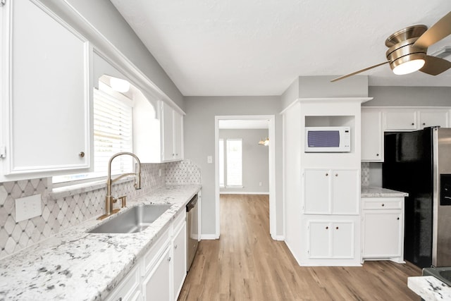 619 Shenandoah Dr, Shenandoah, TX 77381 - kitchen with a sink, appliances with stainless steel finishes, white cabinetry, and light wood finished floors