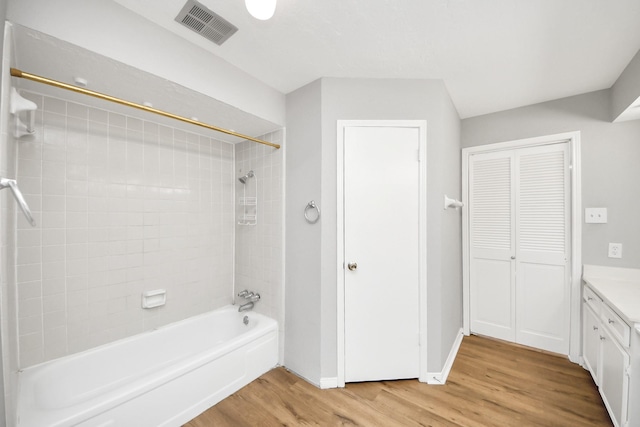 619 Shenandoah Dr, Shenandoah, TX 77381 - bathroom with visible vents, baseboards, bathtub / shower combination, vanity, and wood finished floors